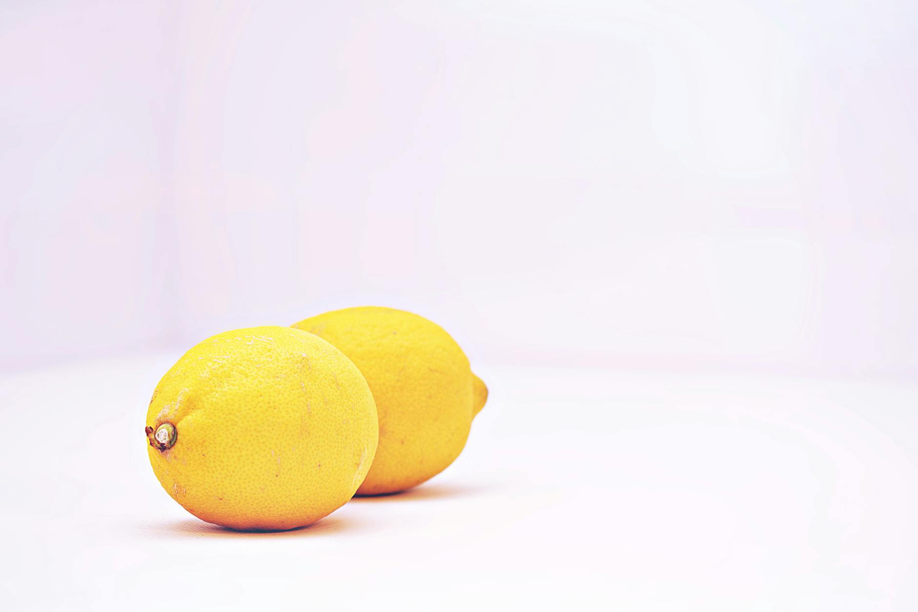Fresh lemons arranged on a minimalist white background, symbolizing fresh approaches to private pleasure