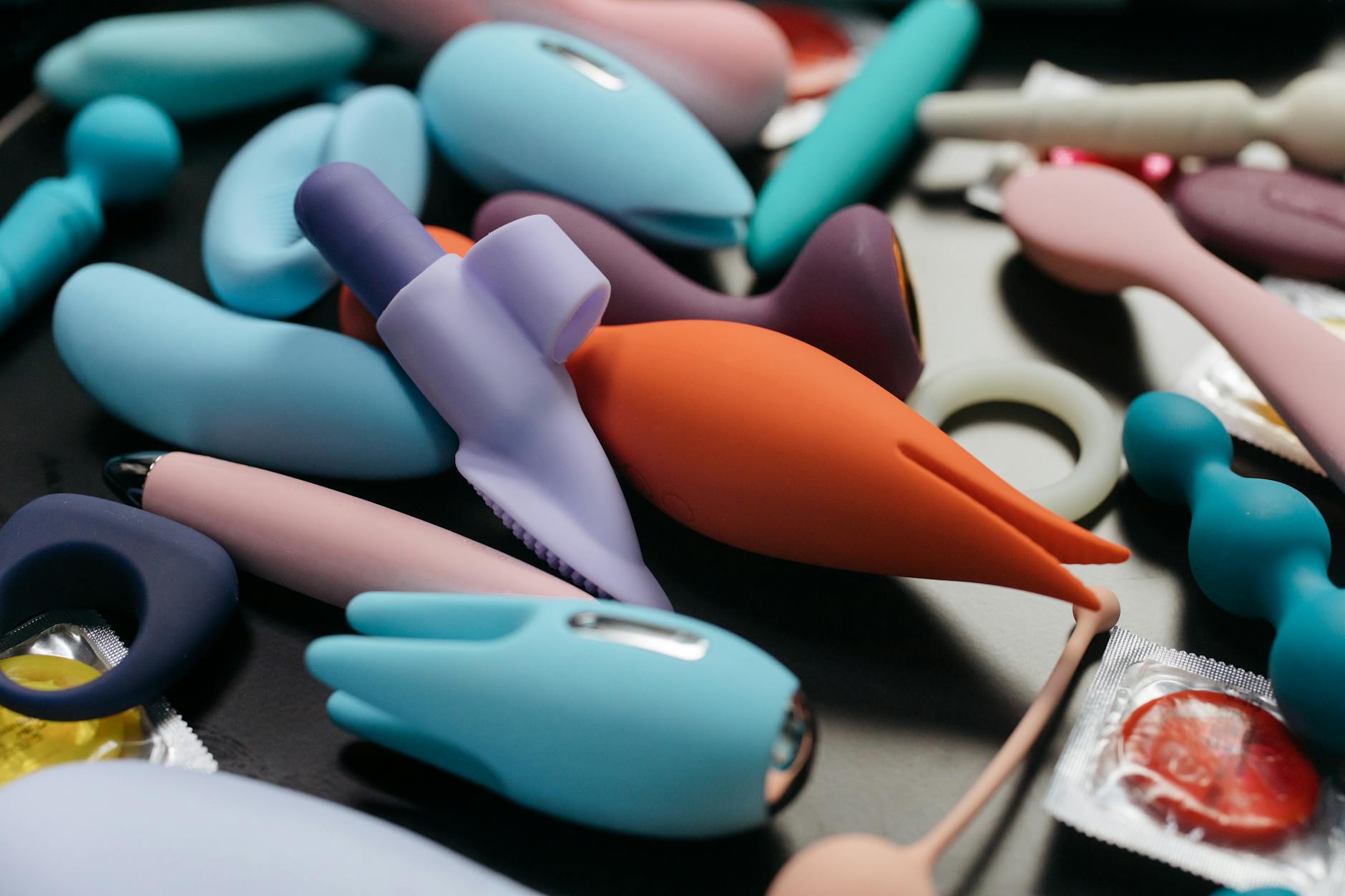 An array of colorful adult toys and vibrators displayed together
